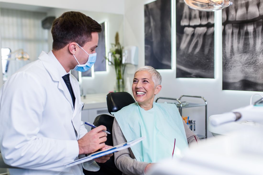 Dentist reviewing treatment plan with smiling senior patient at Devoted Dental Group