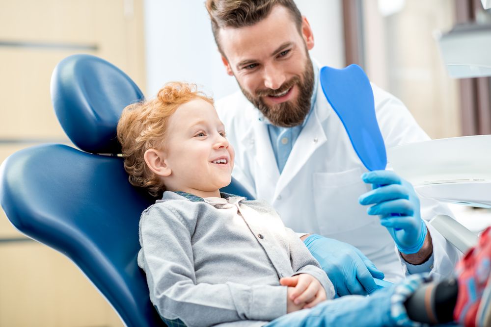 Happy child patient with friendly dentist at Devoted Dental Group Metro Detroit